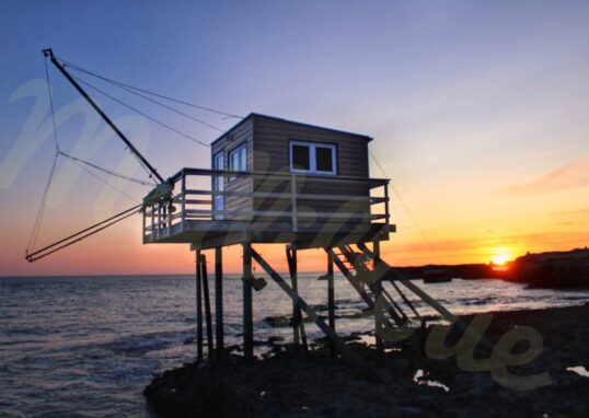 Cabane de pêcheur sur pilotis sur fond de coucher de soleil