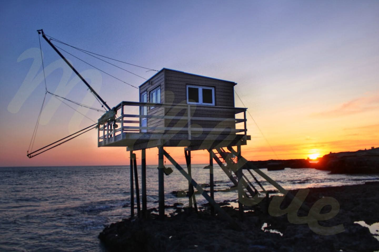 Cabane de pêcheur sur pilotis sur fond de coucher de soleil