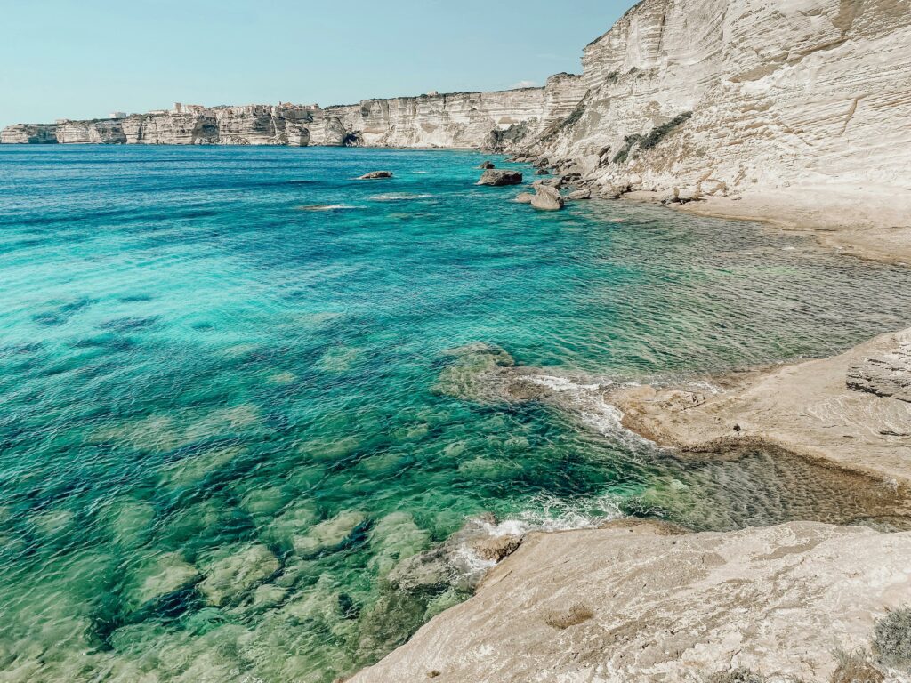 plage rocailleuse avec falaises et eaux turquoises