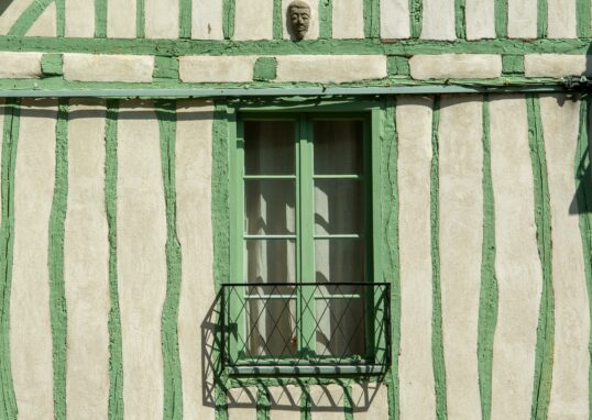 Maison rayée blanche et verte avec une fenêtre verte