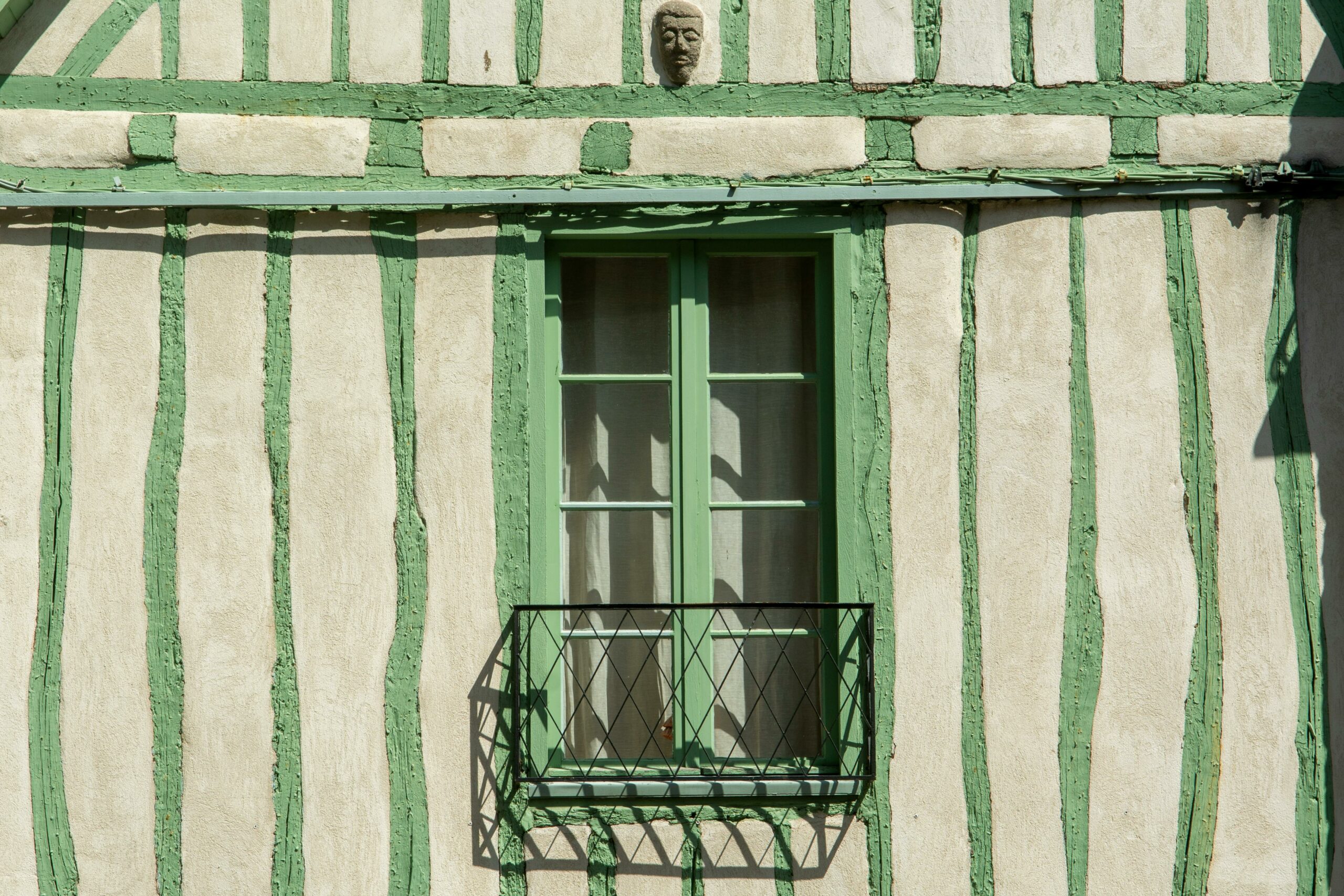 Maison rayée blanche et verte avec une fenêtre verte