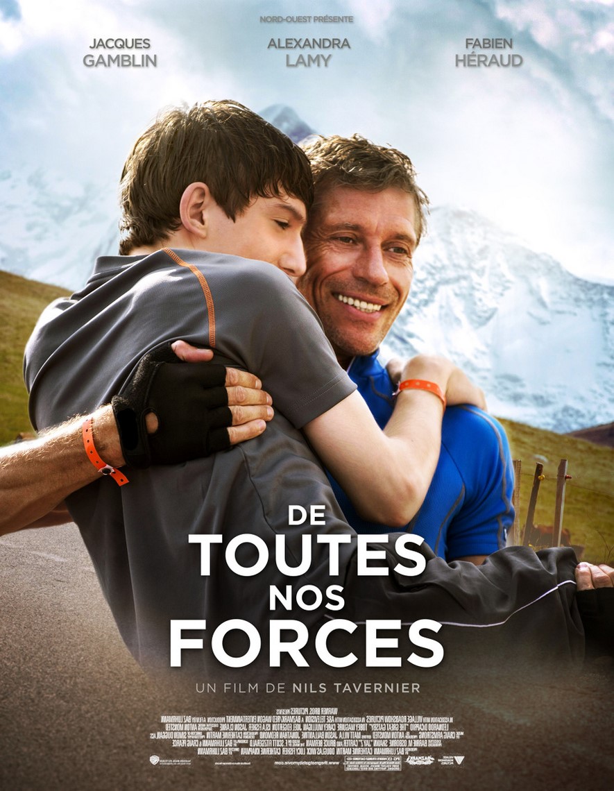 Affiche du film "De toutes nos forces" en couleurs. Un homme souriant porte dans ses bras un jeune homme.