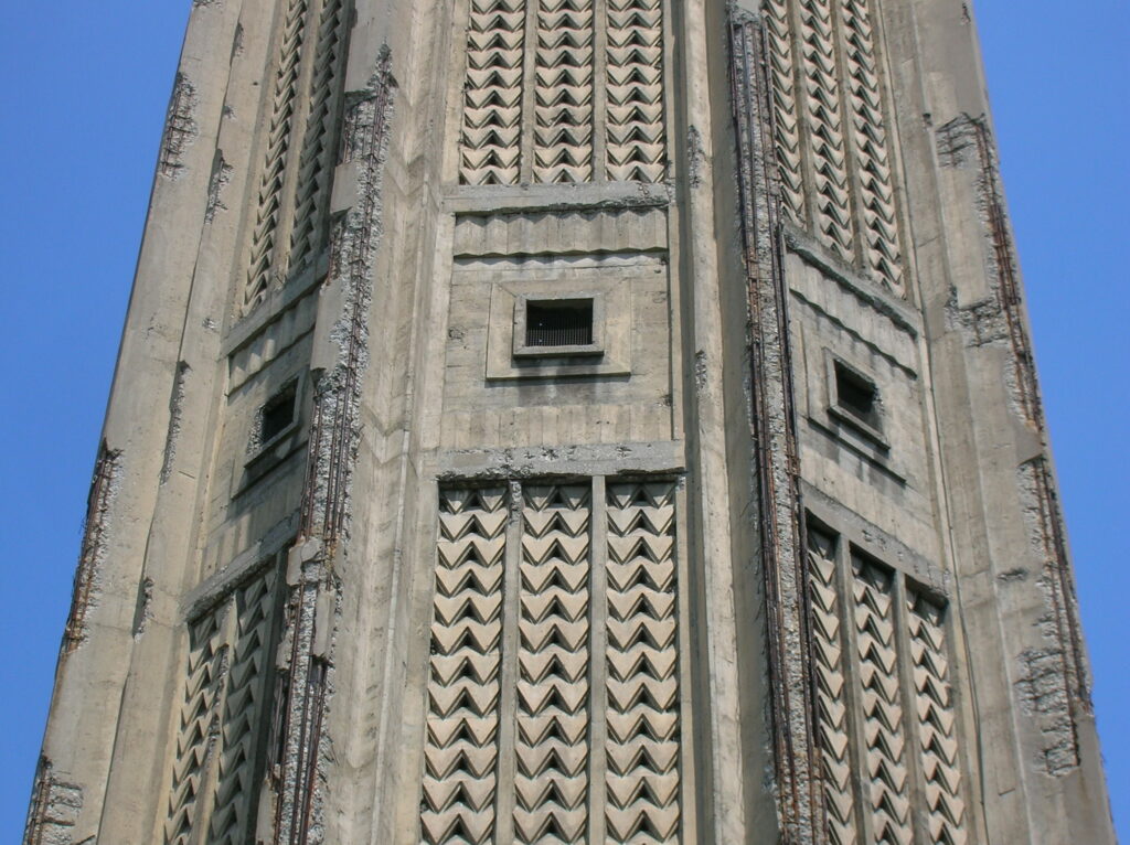 Photo rapprochée de la tour Perret où le béton fissuré laisse entrevoir l'armature en acier