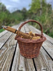 panier en osier posé sur un plancher de bois dans la nature avec à l intérieur une fourcole